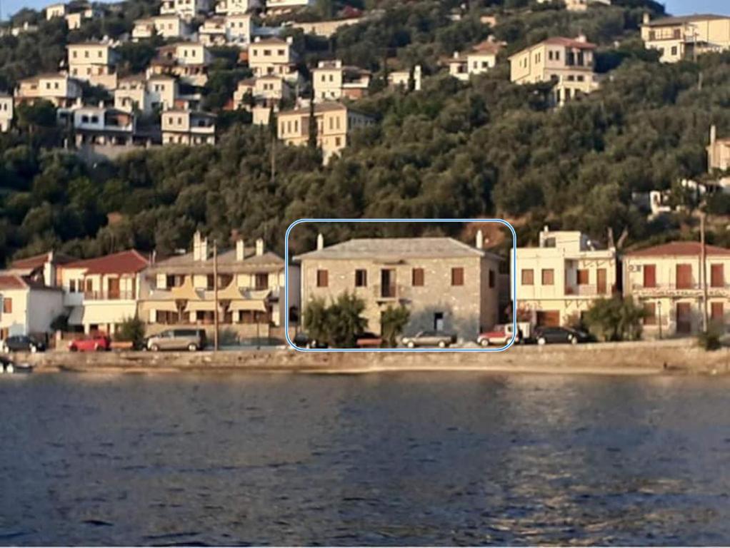 a group of houses on a hill next to the water at GRAND Boutique Studios in Afissos