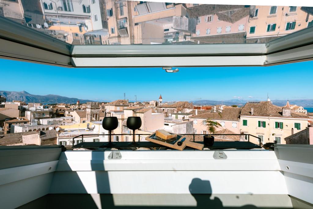 Cień osoby robiącej zdjęcie miasta z okna w obiekcie Vailato Loft Suites w Korfu