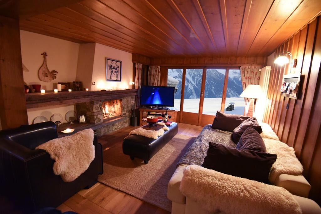 韋爾比耶的住宿－Ski-in, Chalet-style appt - 1 Min Walk to Lift，带沙发、电视和壁炉的客厅