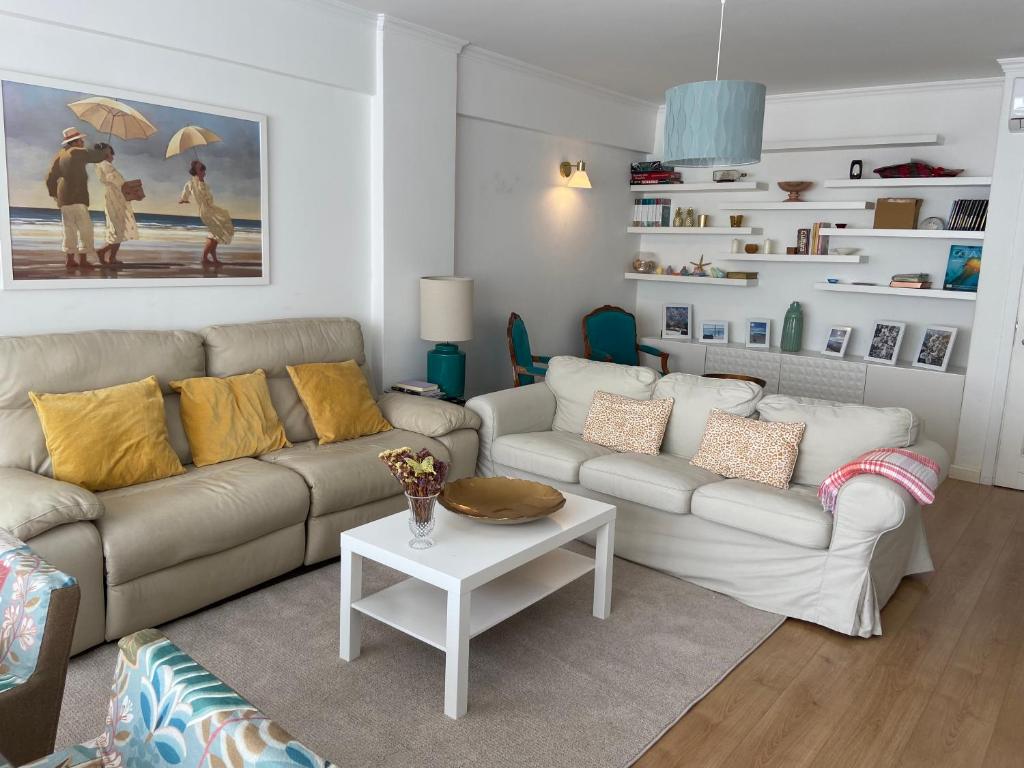 a living room with two couches and a table at Cosy Avenida Apartment in Faro