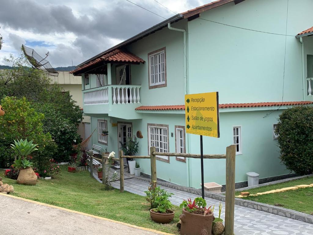 a blue house with a yellow sign in front of it at Itaporanga Pousada in Santa Maria Madalena
