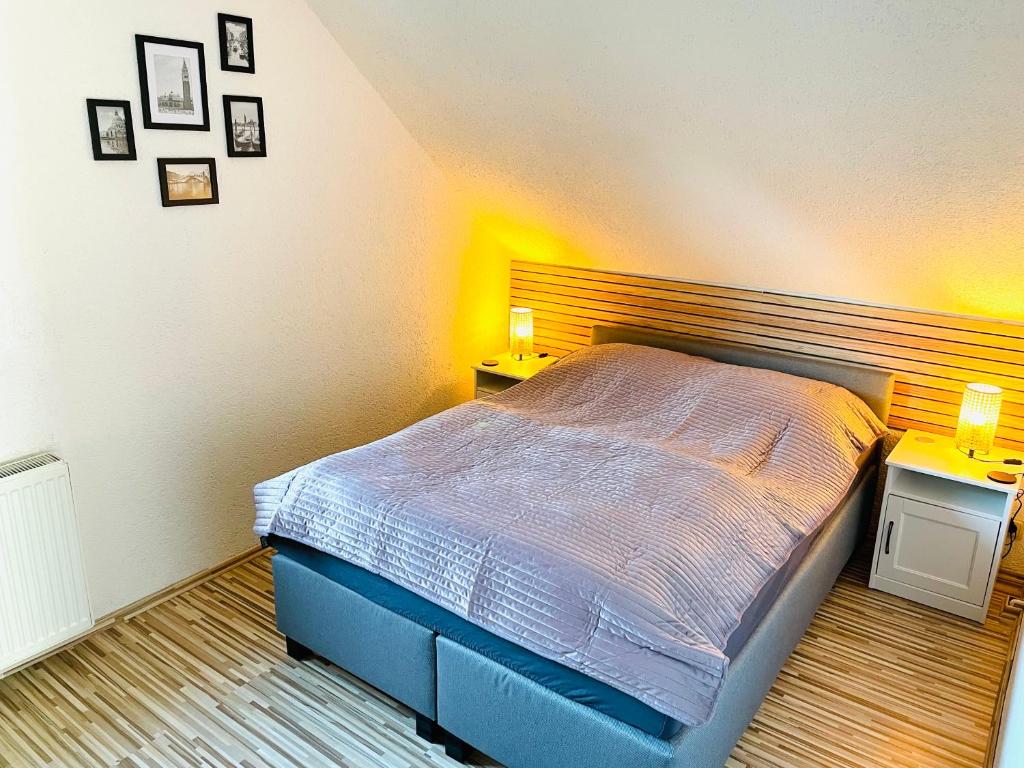 una camera da letto con un letto con due comodini e due lampade di Schöne ruhige Ferienwohnung - in Eisenach mit Kamin - Nahe Karolinentalbrücke - Hund ja a Eisenach