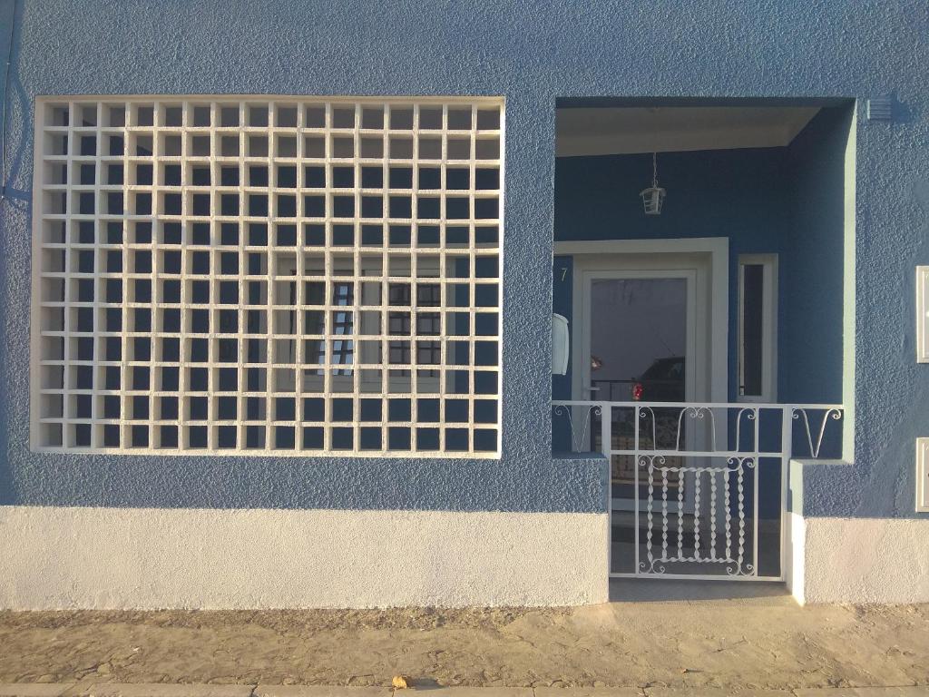 a blue building with a gate in front of a door at Casa Fisher in Vendas Novas