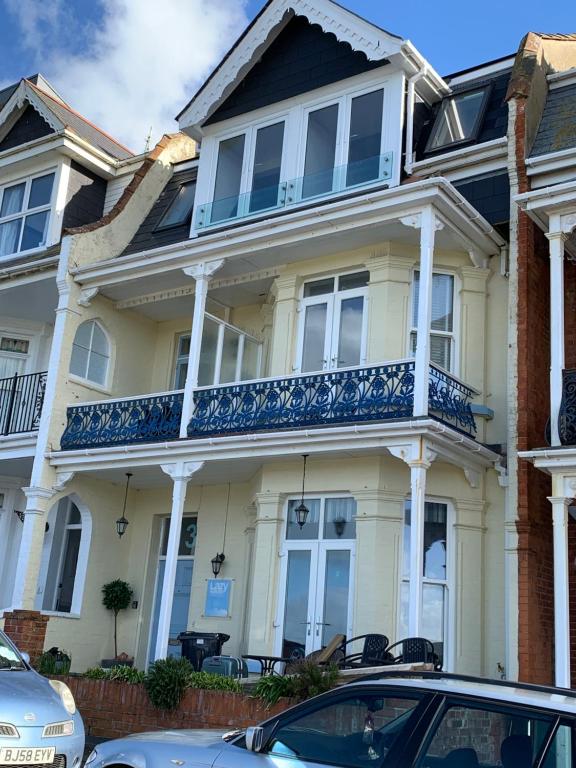 a large white house with a blue balcony at Lazy Waves Boutique B&B in Newquay