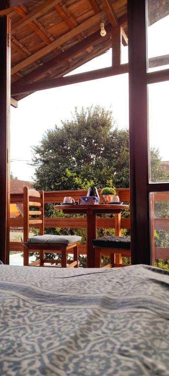 a bedroom with a bed and two benches on a porch at Aconchego Penedo in Penedo