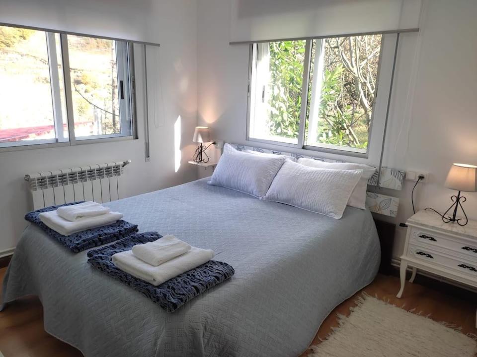 1 dormitorio con 1 cama grande y 2 toallas. en Casa Loureira -Cabo do Mundo, Ribeira Sacra, en Rosende