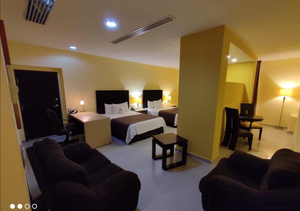 une chambre d'hôtel avec deux lits et un canapé dans l'établissement Hípico inn Hotel, à Poza Rica de Hidalgo