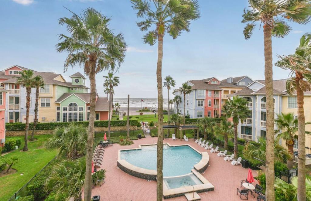 una vista aérea de un complejo con piscina y palmeras en Island Getaway en Galveston