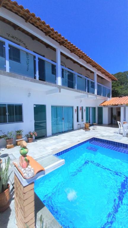 a large swimming pool in front of a house at Casa de temporada Âncora dos Sonhos Pirenópolis Goiás in Pirenópolis