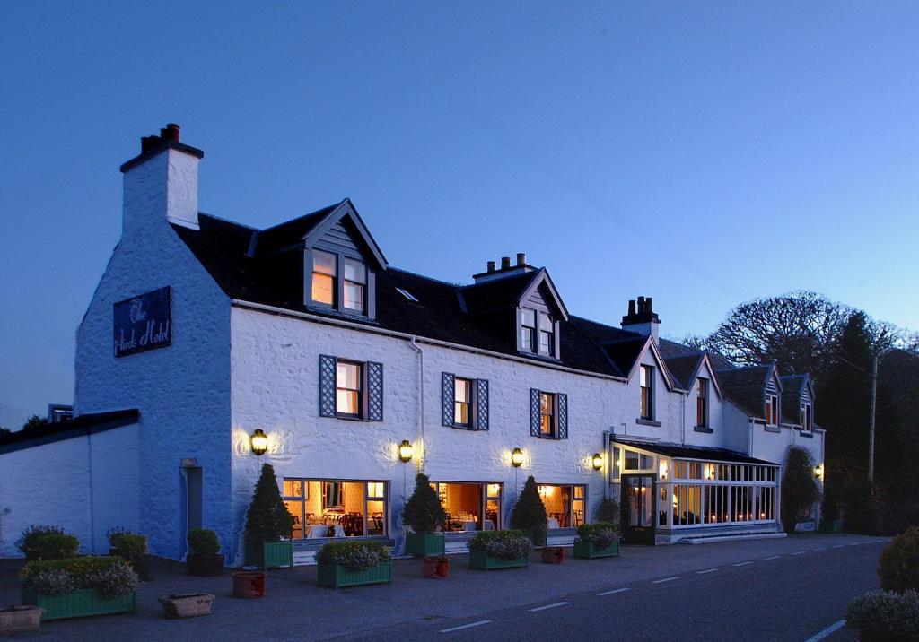 a large white building with lights on at The Airds Hotel and Restaurant in Port Appin