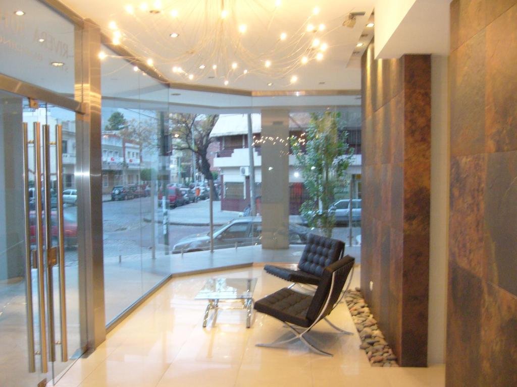 a lobby with two chairs and a table in a building at Urquiza Tower Hermoso departamento con cochera in Buenos Aires