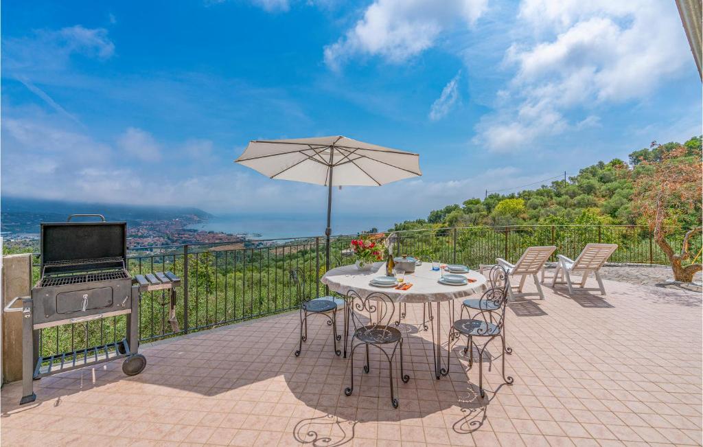 a patio with a table and an umbrella and a grill at 1 Bedroom Cozy Home In Diano Marina in Diano Marina