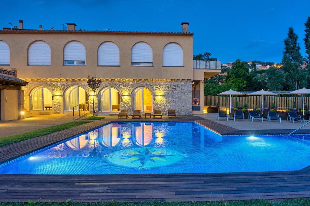 a villa with a swimming pool in front of a building at Hostalet de Begur - Adults Only in Begur