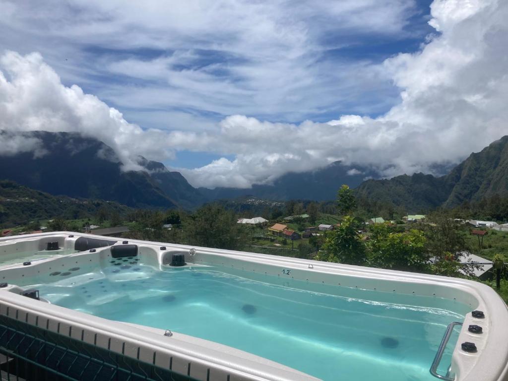 d'un bain à remous avec des montagnes en arrière-plan. dans l'établissement Ô cœur de l’île, à Salazie