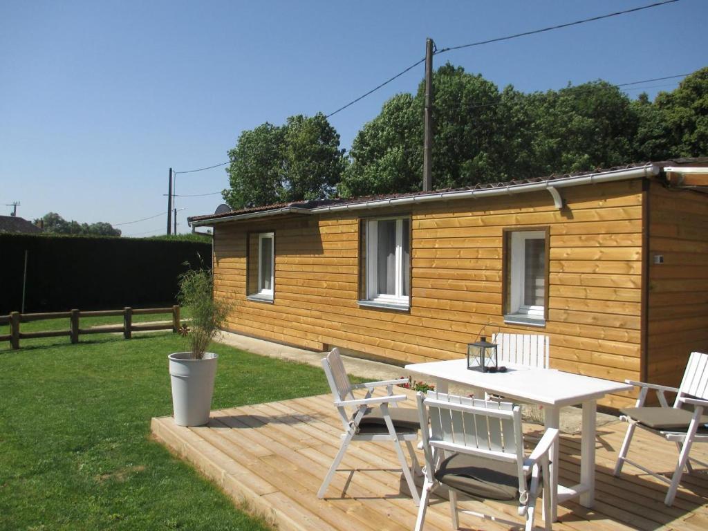 a wooden cabin with a table and chairs on a deck at LES HERISSONS in Étricourt-Manancourt
