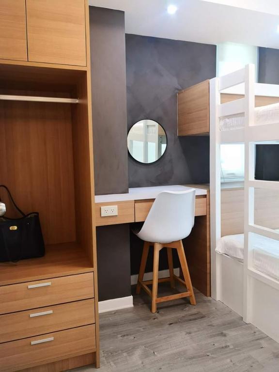 a bedroom with a desk with a chair and a bunk bed at Manila Urban Resort at Azure in Manila