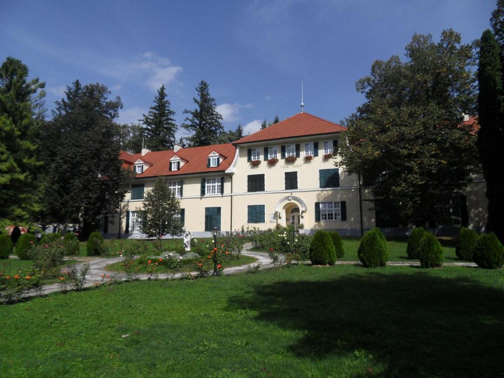 a large white house with a red roof at Apartments Vektor Vila Golf in Rogaška Slatina