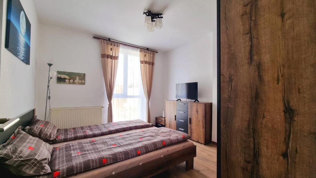 a bedroom with a bed and a dresser and a window at Dabe Hd in Hunedoara