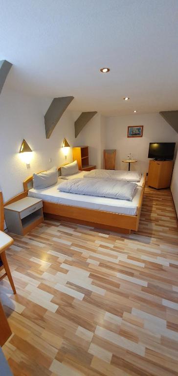 1 dormitorio con 1 cama grande y suelo de madera en Hotel zur Krone, en Hameln