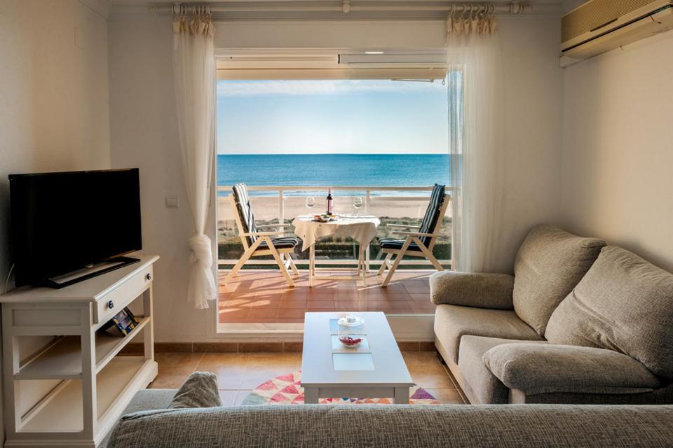 un soggiorno con divano e vista sull'oceano di APARTAMENTO EN PRIMERISIMA LINEA DE PLAYA n 10 a Playa de Xeraco