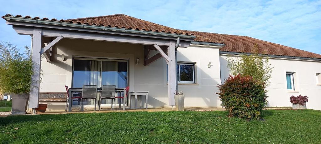 une maison blanche avec une table et des chaises dans une cour dans l'établissement La bellevue, à Montcléra