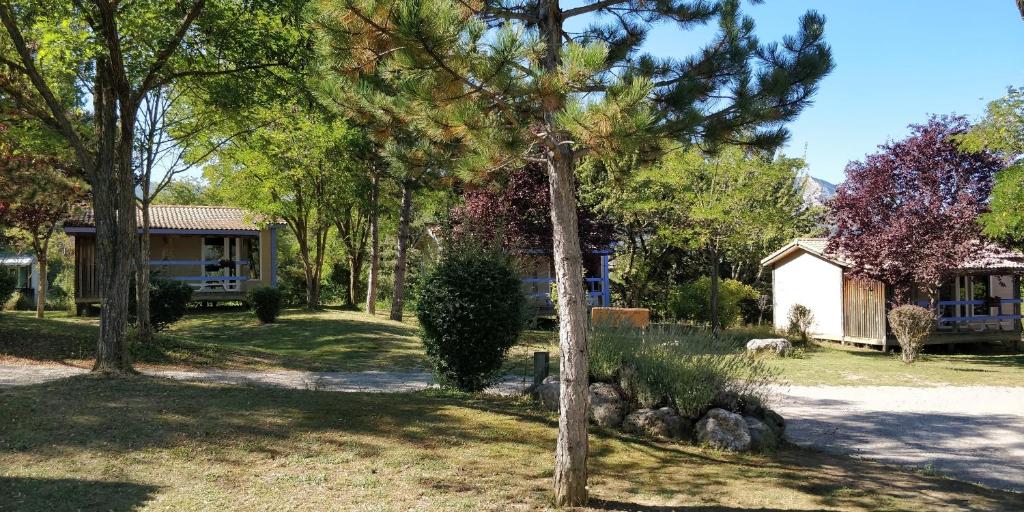 une maison avec un arbre dans la cour dans l&#39;établissement Camping le Couriou, à Recoubeau-Jansac