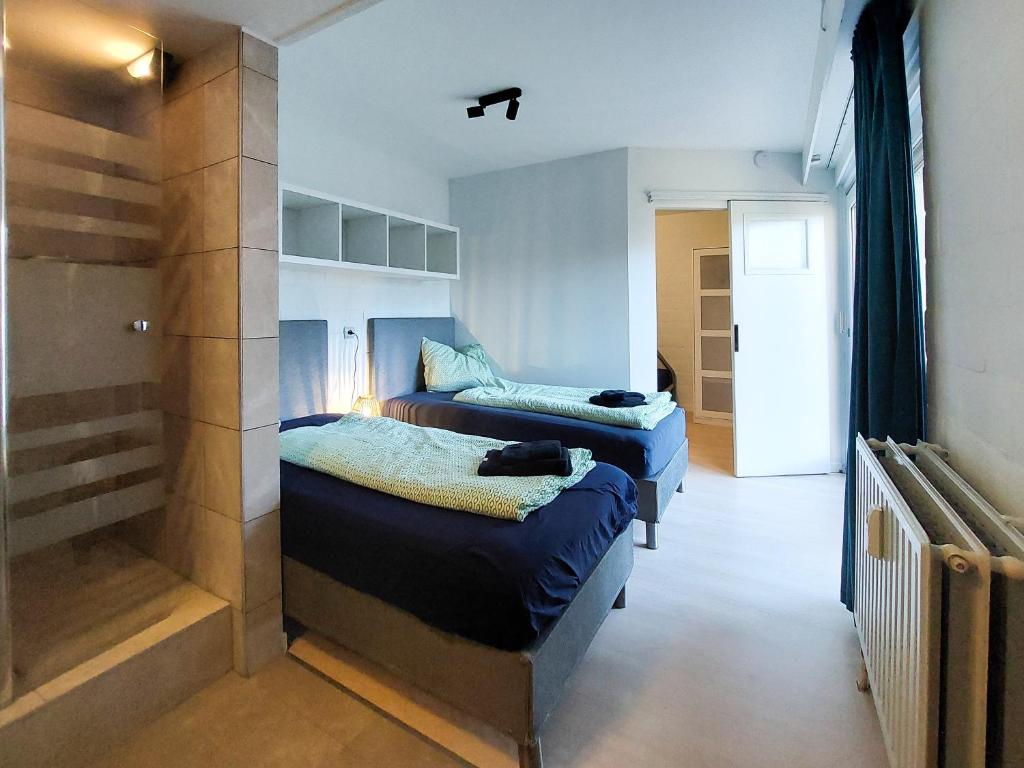 a bedroom with two beds and a walk in closet at Den 1 Hengelhoef in Houthalen-Helchteren