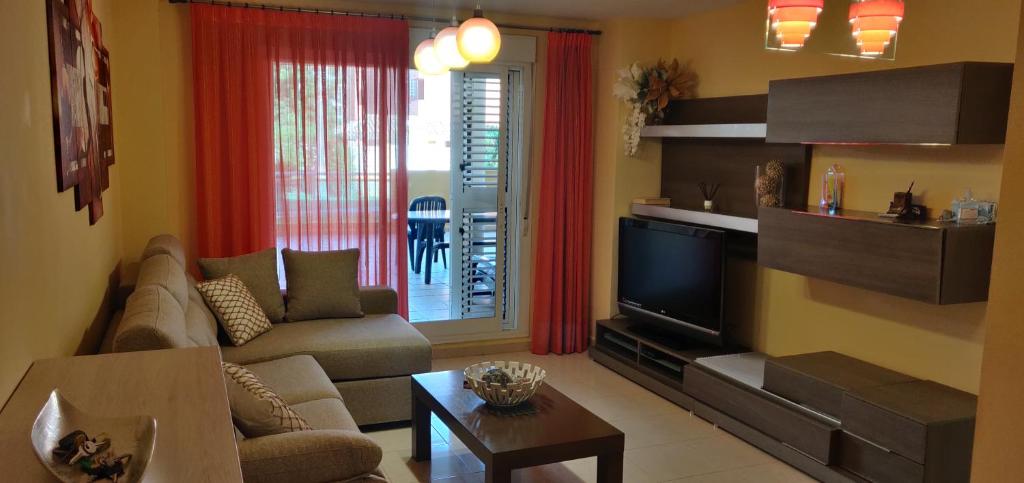 un soggiorno con un divano e una TV di Apartamento Brisas de Denia a Denia