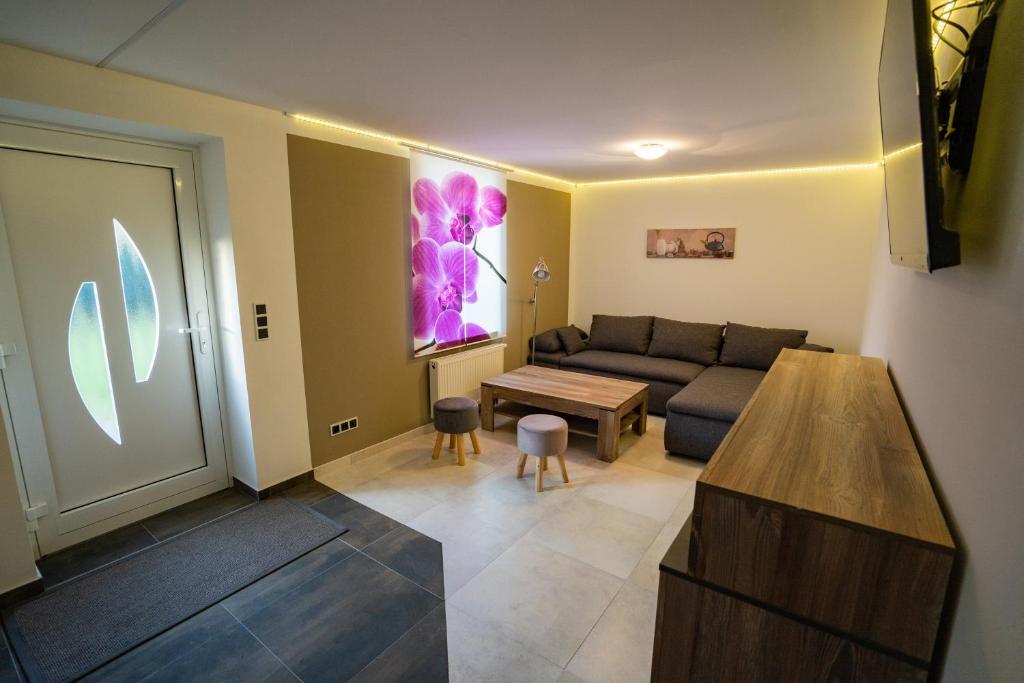 een woonkamer met een bank en een tafel bij Das Appartment im Gästehaus im Rittergut Keulrod in Bischofrod