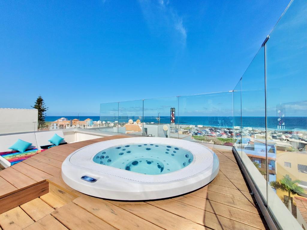 a hot tub on a deck with a view of the ocean at Puerto Azul in Puerto de la Cruz