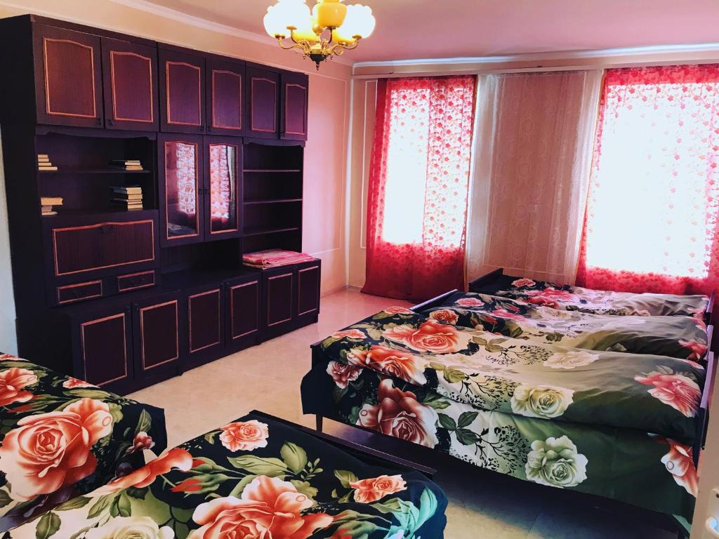 a bedroom with two beds and red curtains at Hayq Guest House in Goris