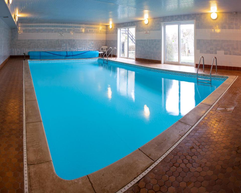 a large swimming pool with blue lights on it at Cliff House Holiday Cottages in Ebberston