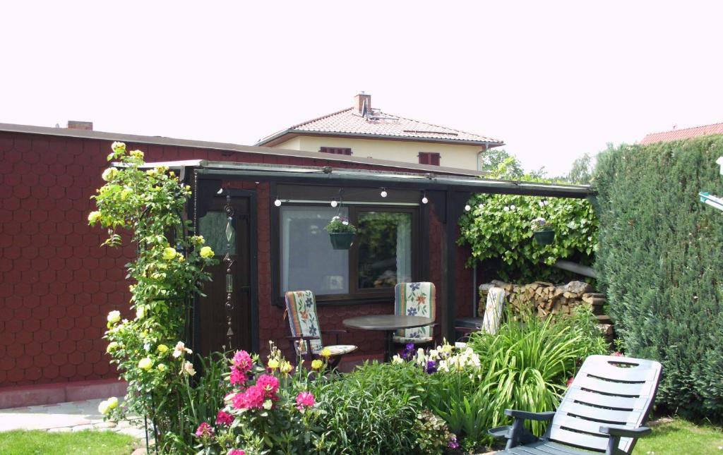 a shed with a table and chairs in a garden at Ferienwohnung Tensfeldt in Lübben