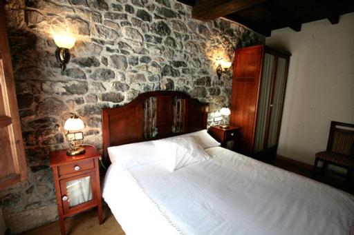 A bed or beds in a room at Hotel Rural Casa Cueto