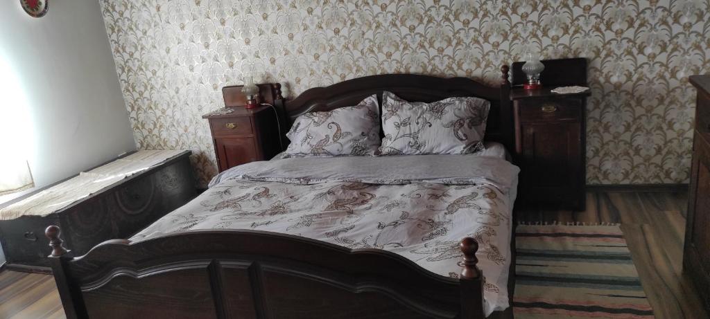 1 dormitorio con 1 cama con marco de madera en Pensiunea Ramona, en Viscri
