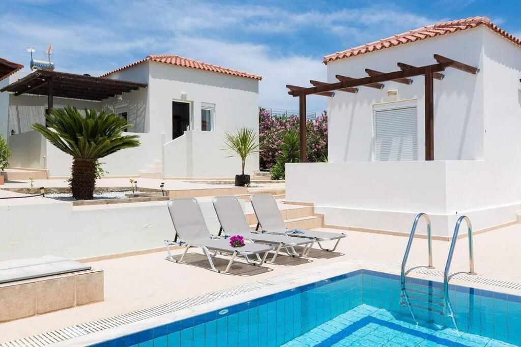 a villa with a swimming pool and a house at Grey House in Chorafakia
