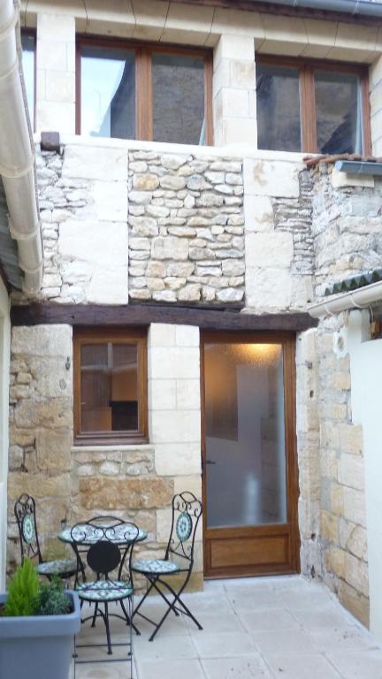 un patio avec des chaises et une table devant un bâtiment dans l'établissement La Grange du Couvent, à Sarlat-la-Canéda