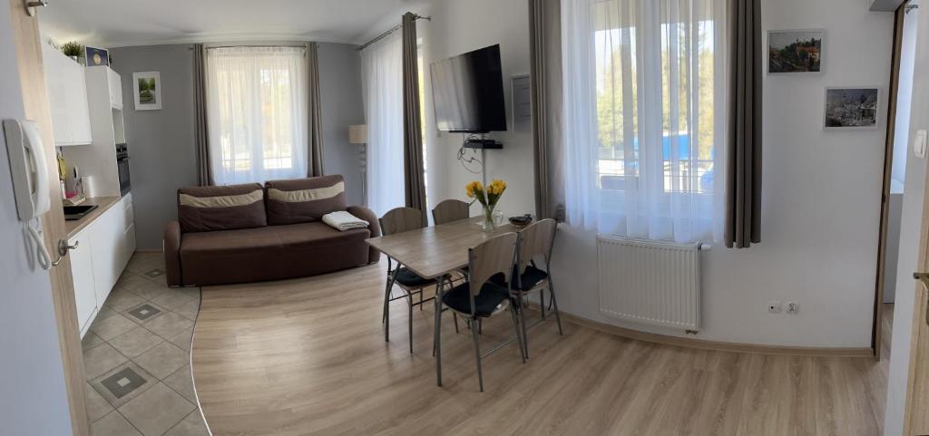 a dining room and living room with a table and chairs at Apartament z dużym balkonem Osiedle Zwycięzców in Polanica-Zdrój