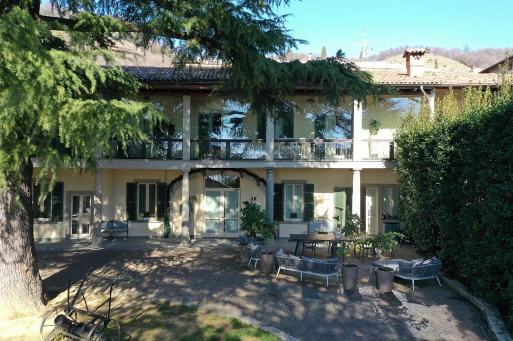 une grande maison avec un arbre en face dans l'établissement Lo Schiaccianoci Bed&Breakfast de Charme, à Scanzorosciate