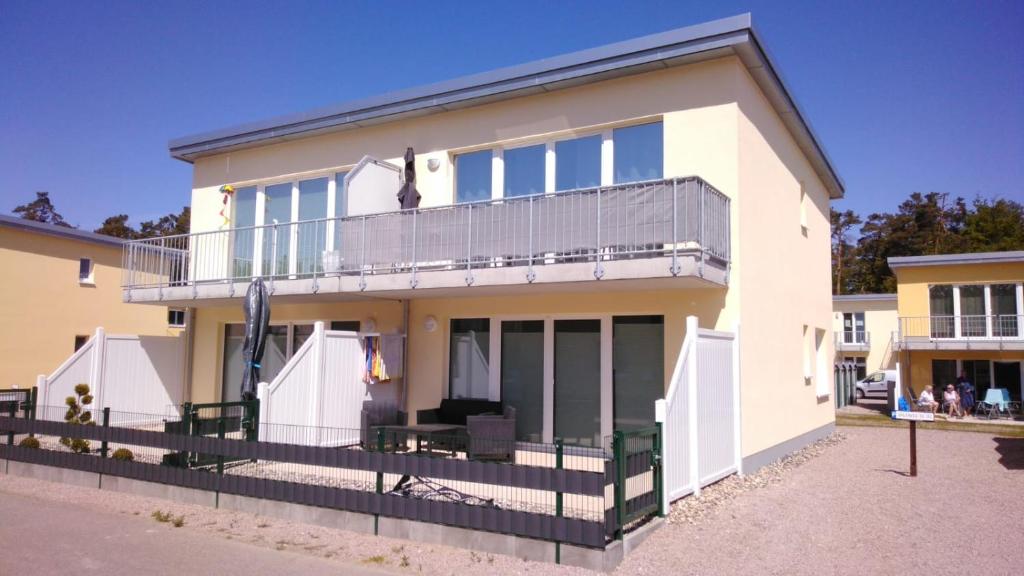 a large white house with a balcony at FEWO Meerhund in Graal-Müritz in Gelbensande