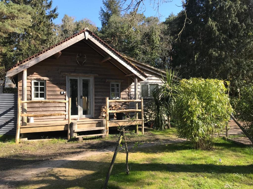 a log cabin with a porch and a door at sika lodge in Wareham