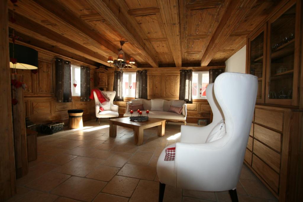 ein Wohnzimmer mit einem Sofa und einem Tisch in der Unterkunft Les Authentics - Le Domaine d'Autrefois & Spa in Bolsenheim
