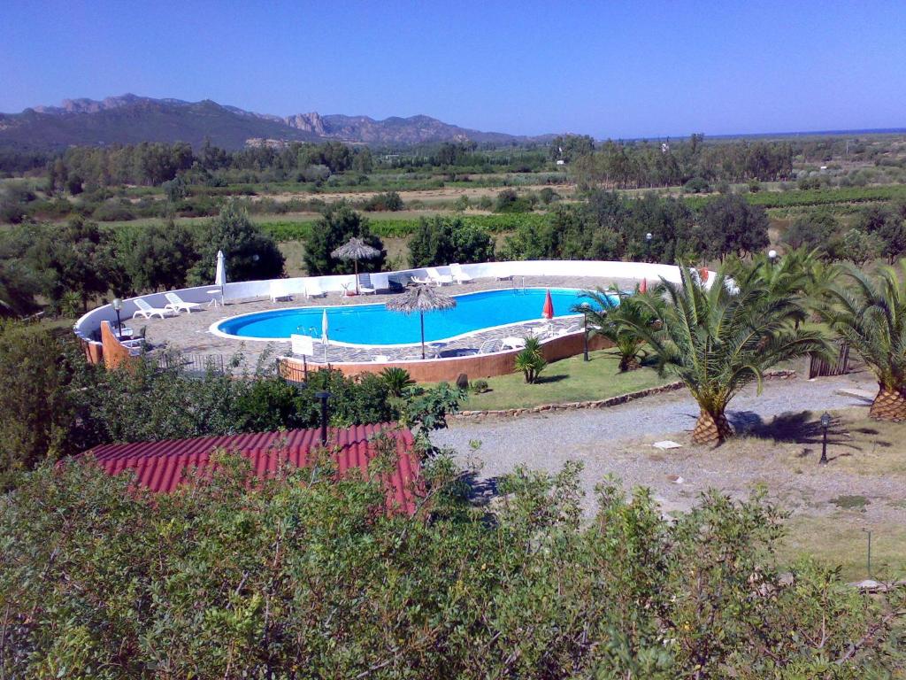 une grande piscine au milieu d'un champ dans l'établissement Il Castello, à Villaputzu