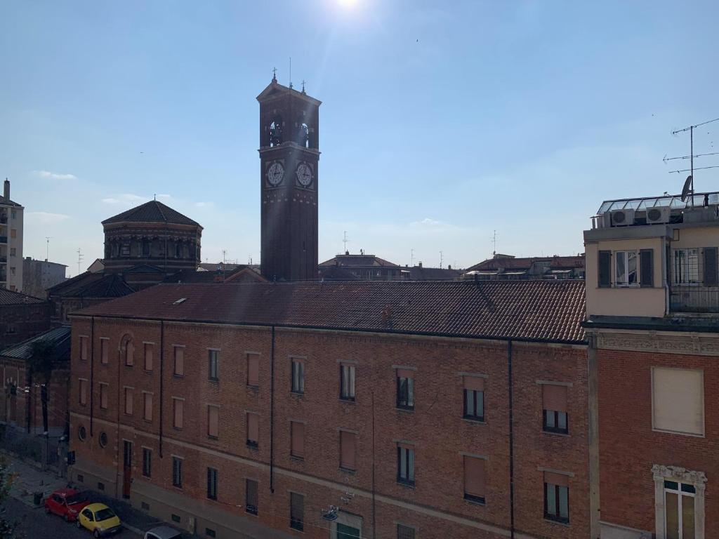 uma torre de relógio no topo de um edifício de tijolos em Bright Place Navigli em Milão