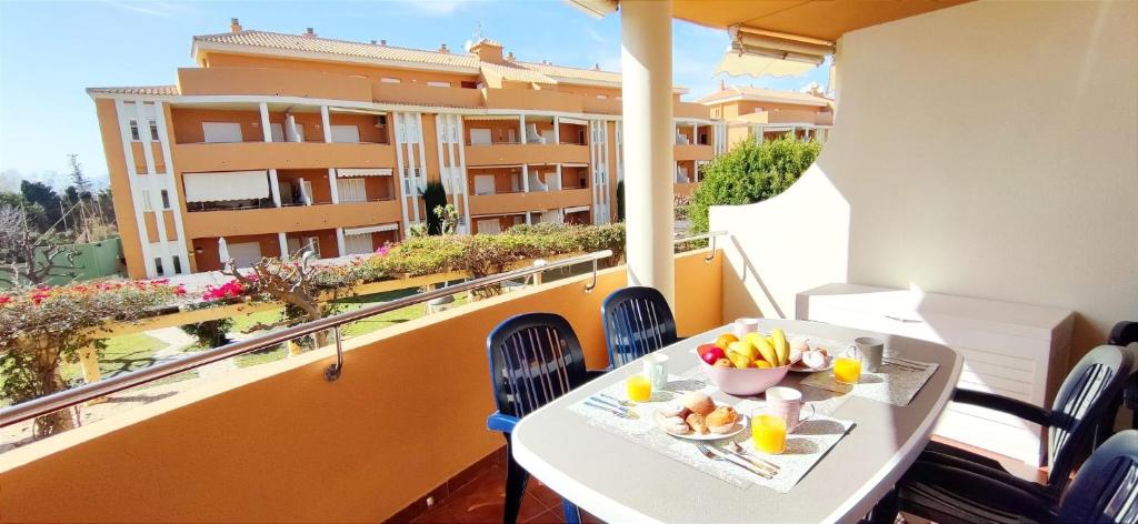 een tafel met fruit op een balkon met een gebouw bij Apartamento Mediterráneo by DENIA COSTA in Denia
