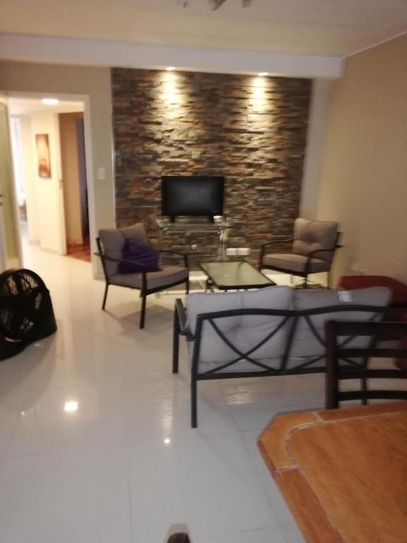 a living room with chairs and a flat screen tv at Santa Rosa in Mendoza