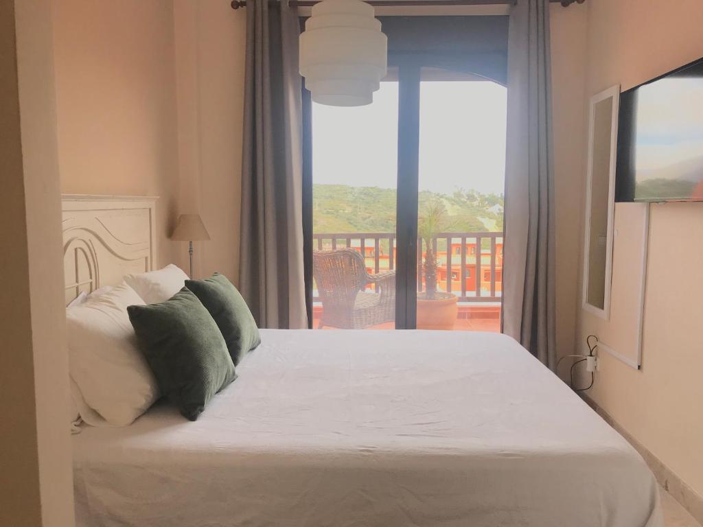 sypialnia z łóżkiem i balkonem z widokiem na okolicę w obiekcie Duplex Penthouse in Estepona- Mountain and Sea views w mieście Estepona