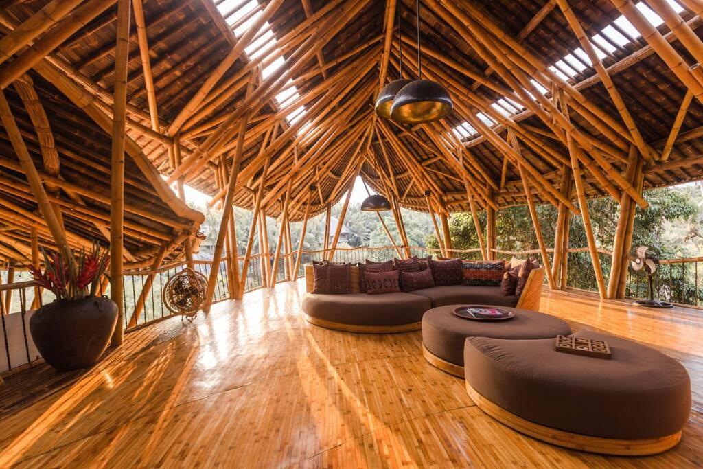 ein Wohnzimmer mit Sofas und Stühlen in einem Gebäude in der Unterkunft Sharma Springs 5 bds Luxurious Bamboo Mansion Pool in Bringkit