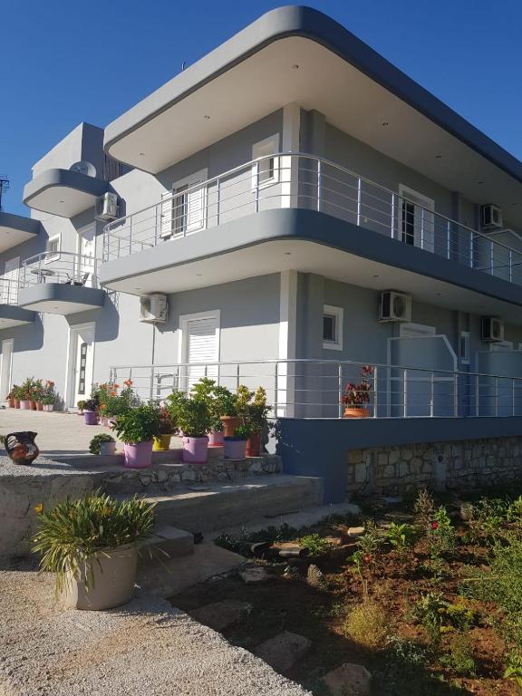 a large building with potted plants in front of it at Victoria Studio Himara in Himare