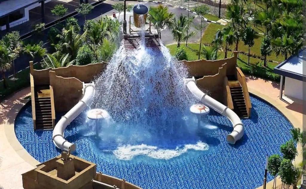 un tobogán de agua en una piscina de un complejo en FRA Dreams @ Swiss Garden Resort Residences en Kuantan